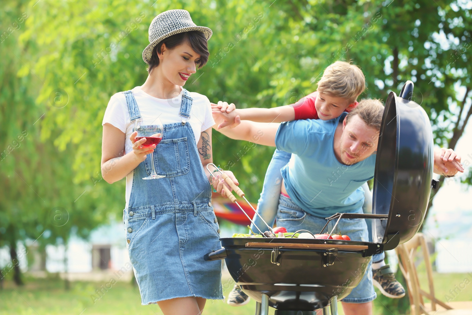 Photo of Happy family having barbecue with modern grill outdoors