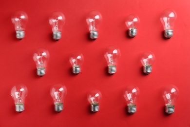 New incandescent lamp bulbs on red background, flat lay