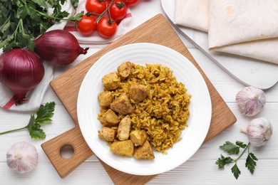Photo of Delicious rice with chicken served on white wooden table, flat lay