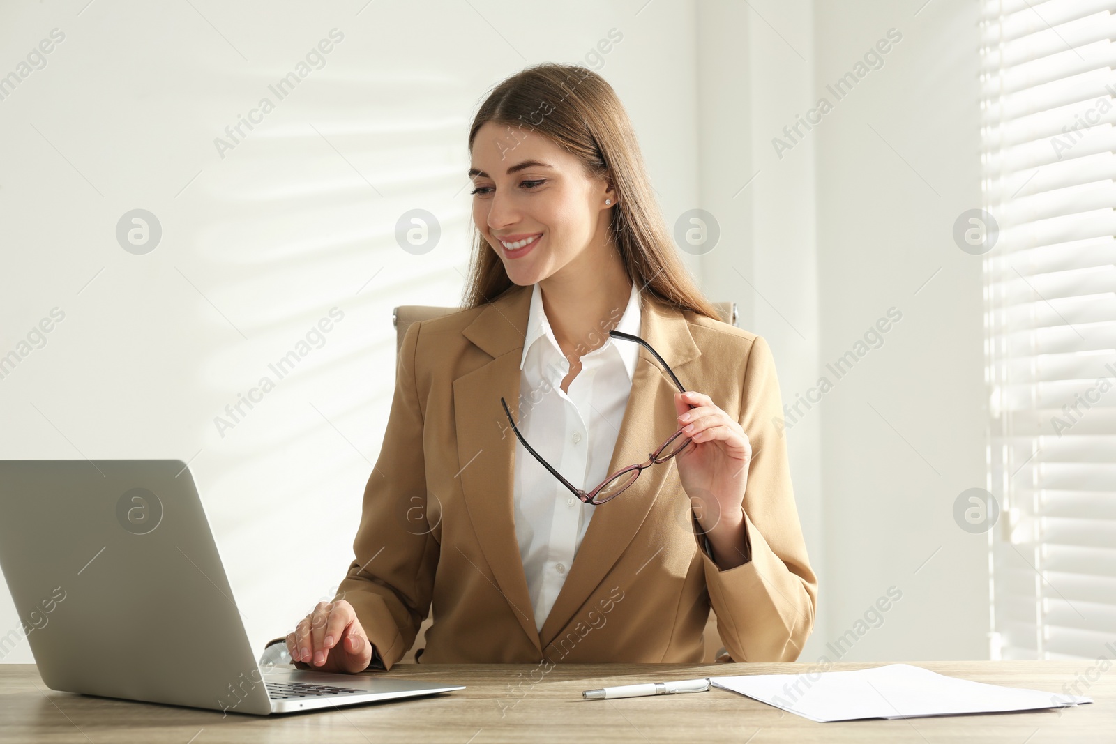 Photo of Portrait of beautiful young businesswoman with laptop at table in office