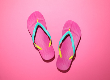 Pair of stylish flip flops on pink background, top view. Beach objects