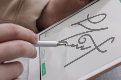 Image of Electronic signature. Man using stylus and tablet, closeup