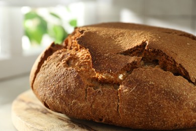 Photo of Freshly baked sourdough bread on light table, closeup