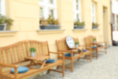 Photo of Blurred view of outdoor cafe with wooden benches