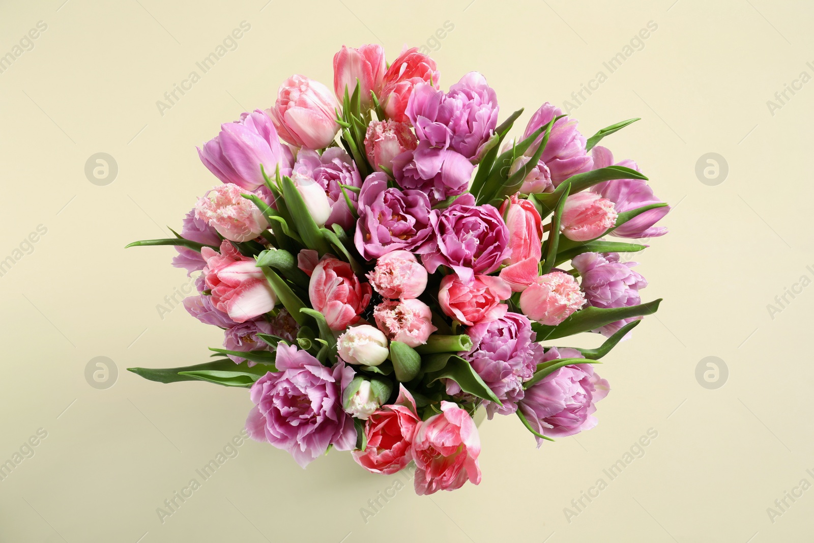 Photo of Beautiful bouquet of colorful tulip flowers on beige background, top view