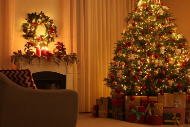 Photo of Beautiful Christmas tree and gifts near fireplace in festively decorated living room