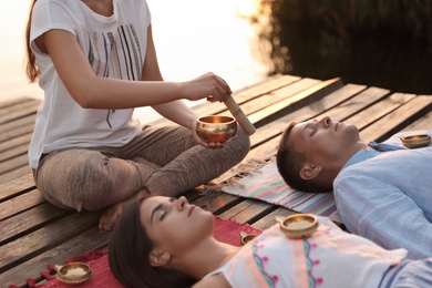 Photo of Couple at healing session with singing bowl outdoors