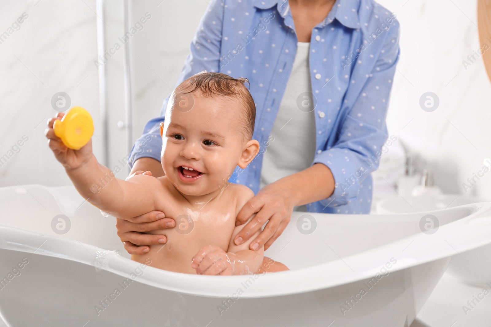 Photo of Mother with her little baby in bathroom