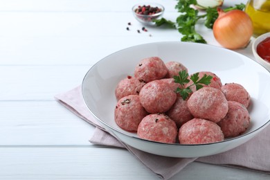 Photo of Many fresh raw meatballs on white wooden table, space for text