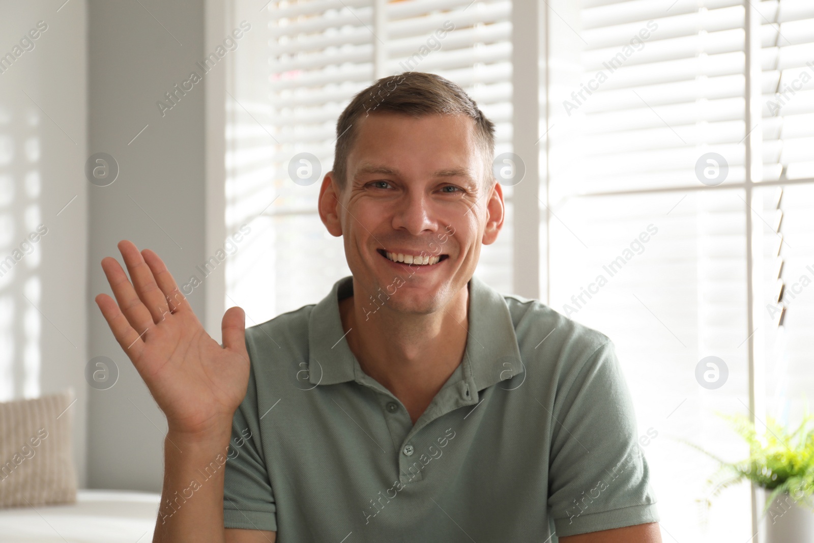 Photo of Man talking to his coworkers through video conference indoors, view from webcam