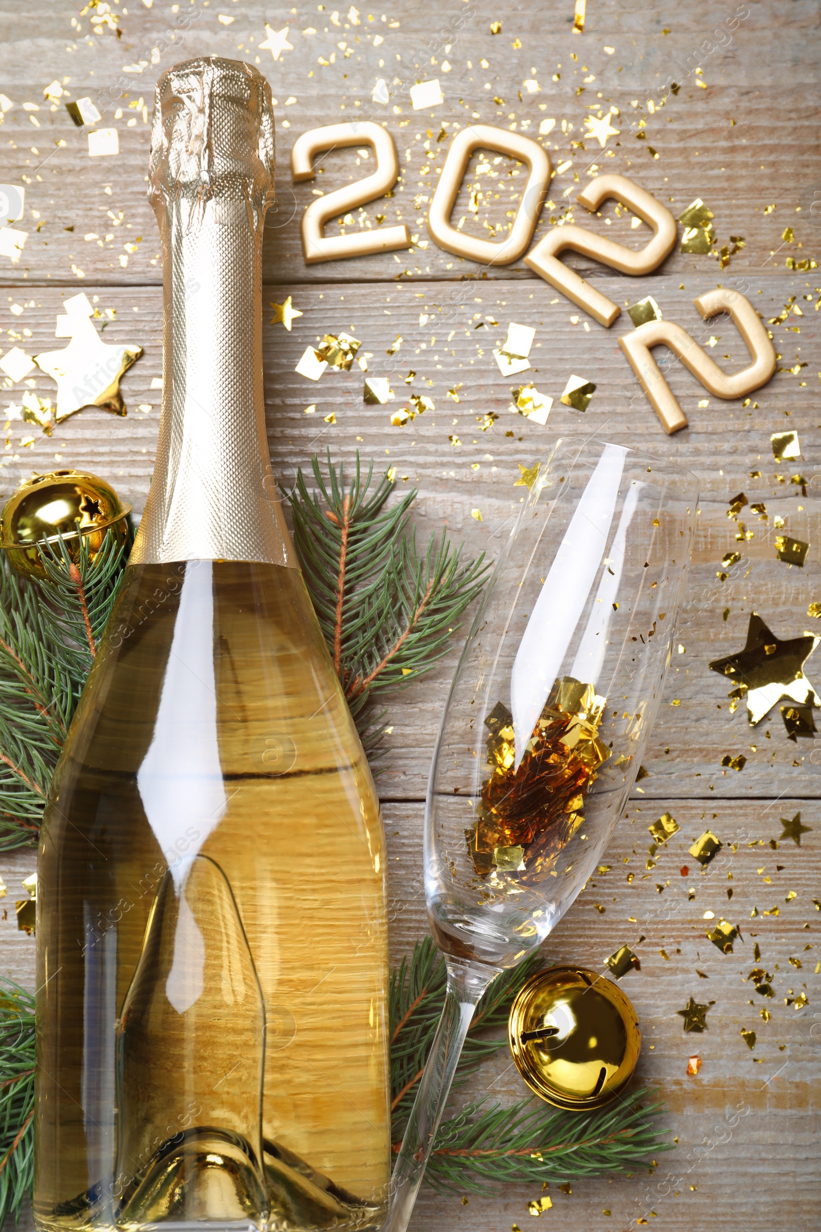 Photo of Happy New Year 2022! Flat lay composition with bottle of sparkling wine on wooden table