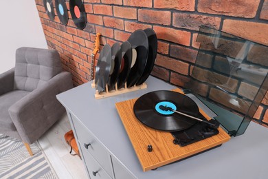 Photo of Wooden player and vinyl records in living room