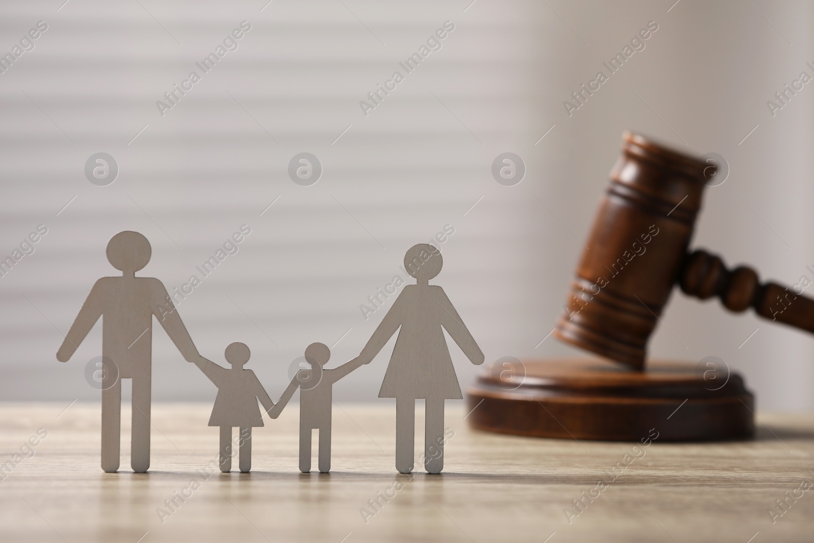 Photo of Family law. Figure of parents with children and gavel on wooden table, space for text