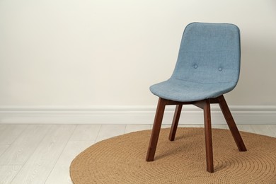 Photo of Stylish grey chair near white wall indoors. Space for text