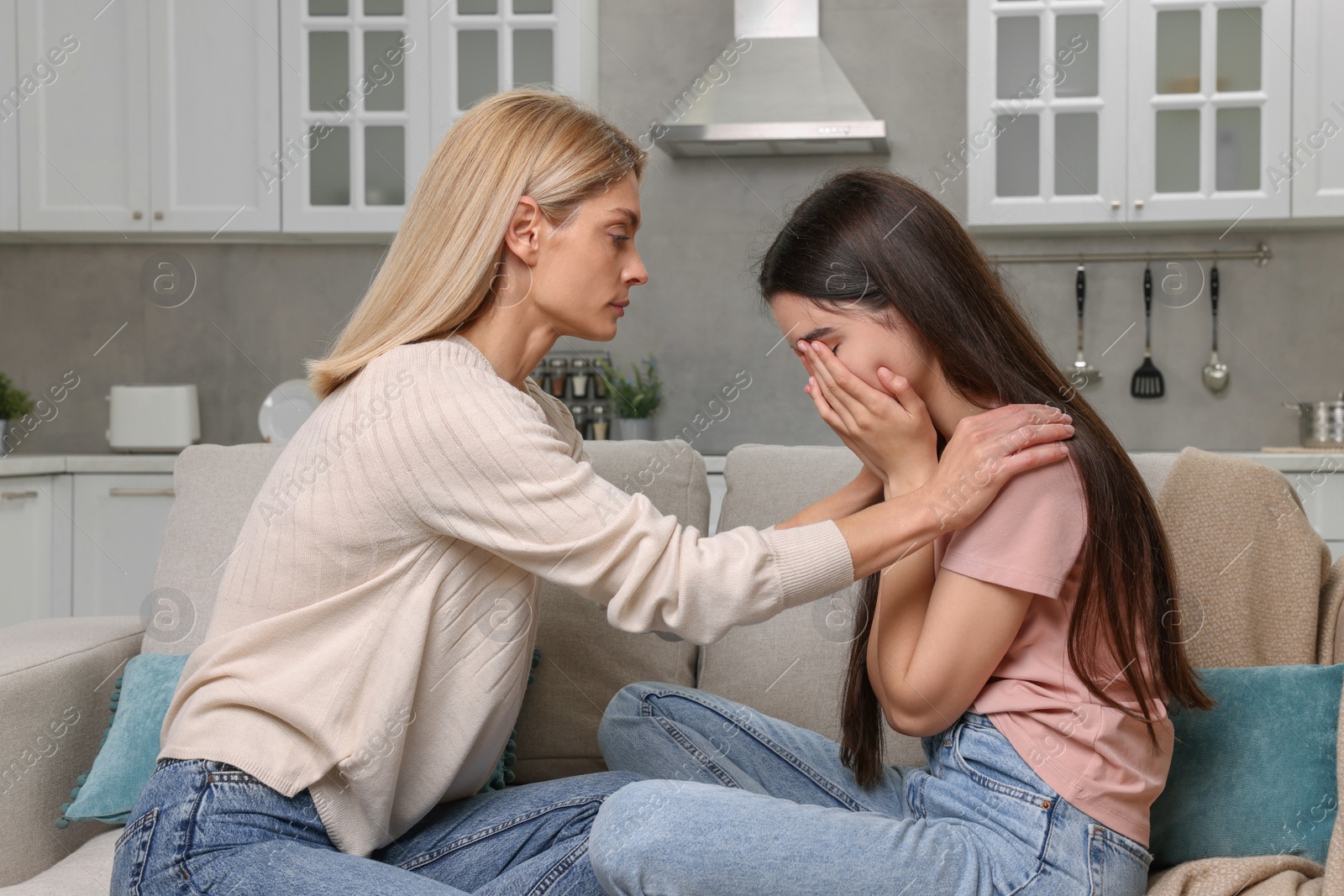 Photo of Mother consoling her upset daughter at home. Teenager problems