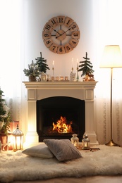 Small fir trees and candles on mantelpiece indoors. Christmas interior design