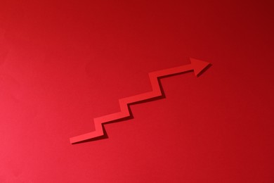One zigzag paper arrow on red background, above view
