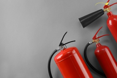 Photo of Fire extinguishers on light grey background, flat lay. Space for text