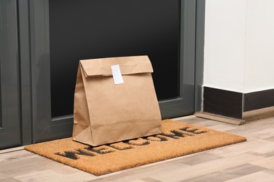 Photo of Paper bag on door mat near entrance indoors