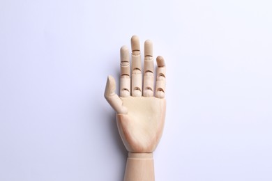 Photo of Wooden mannequin hand on white background, top view