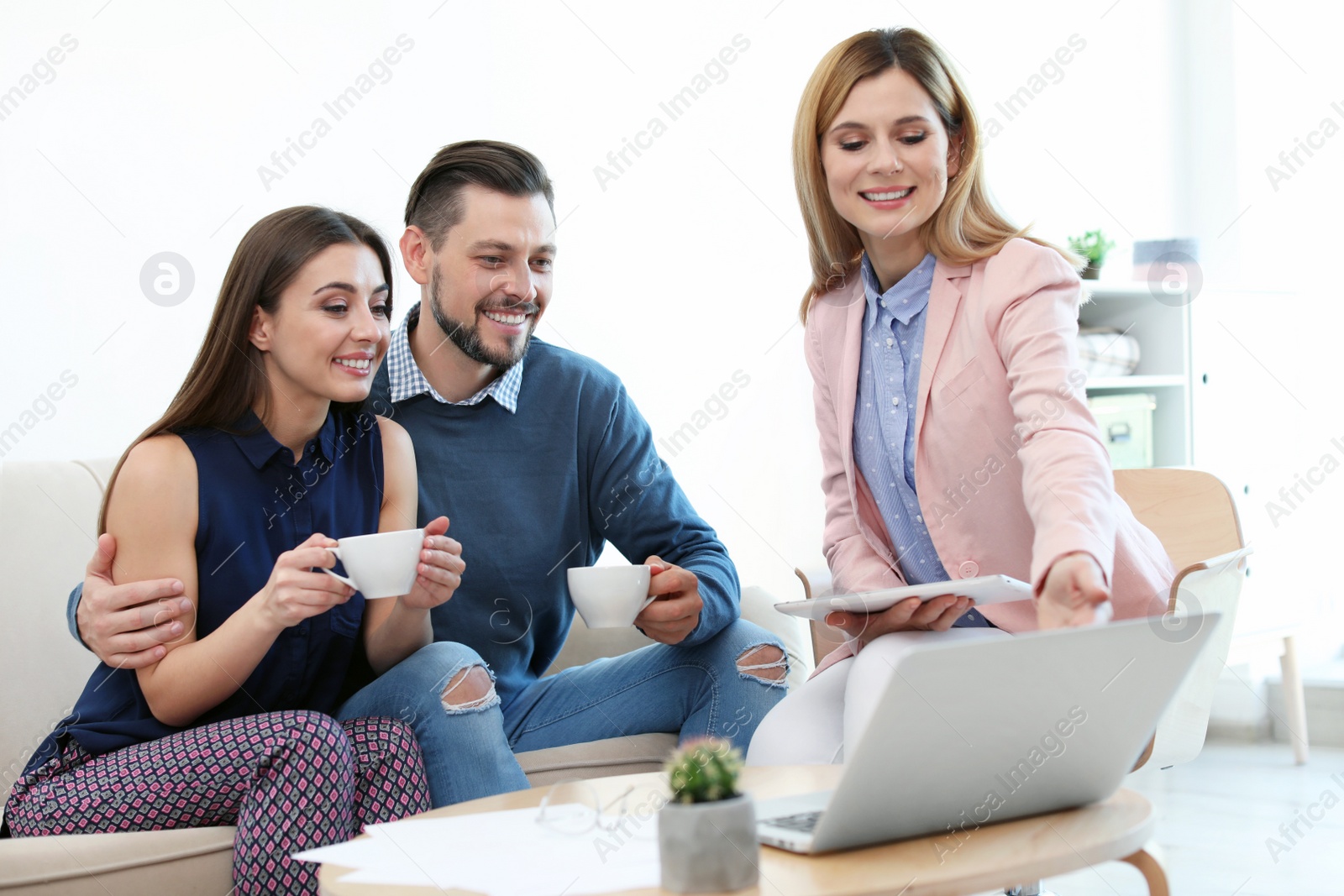 Photo of Female real estate agent working with couple in office