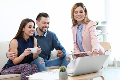 Photo of Female real estate agent working with couple in office