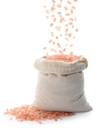 Image of Pink himalayan salt falling into sack on white background