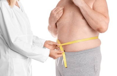 Photo of Doctor measuring senior man's waist on white background. Weight loss