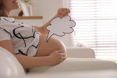 Photo of Pregnant woman with empty paper thought cloud indoors, closeup. Choosing baby name