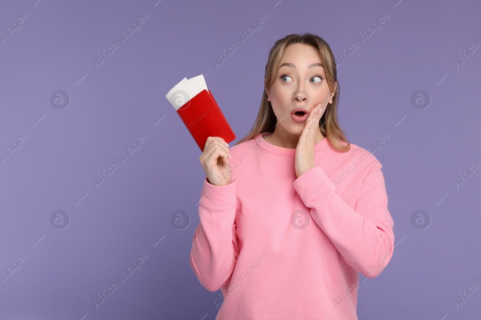 Photo of Emotional young woman with passport and ticket on purple background, space for text