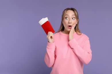 Photo of Emotional young woman with passport and ticket on purple background, space for text