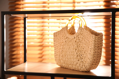 Stylish woman's bag on shelf in boutique