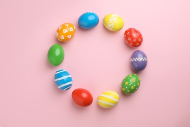 Photo of Decorated Easter eggs and space for text on color background, top view