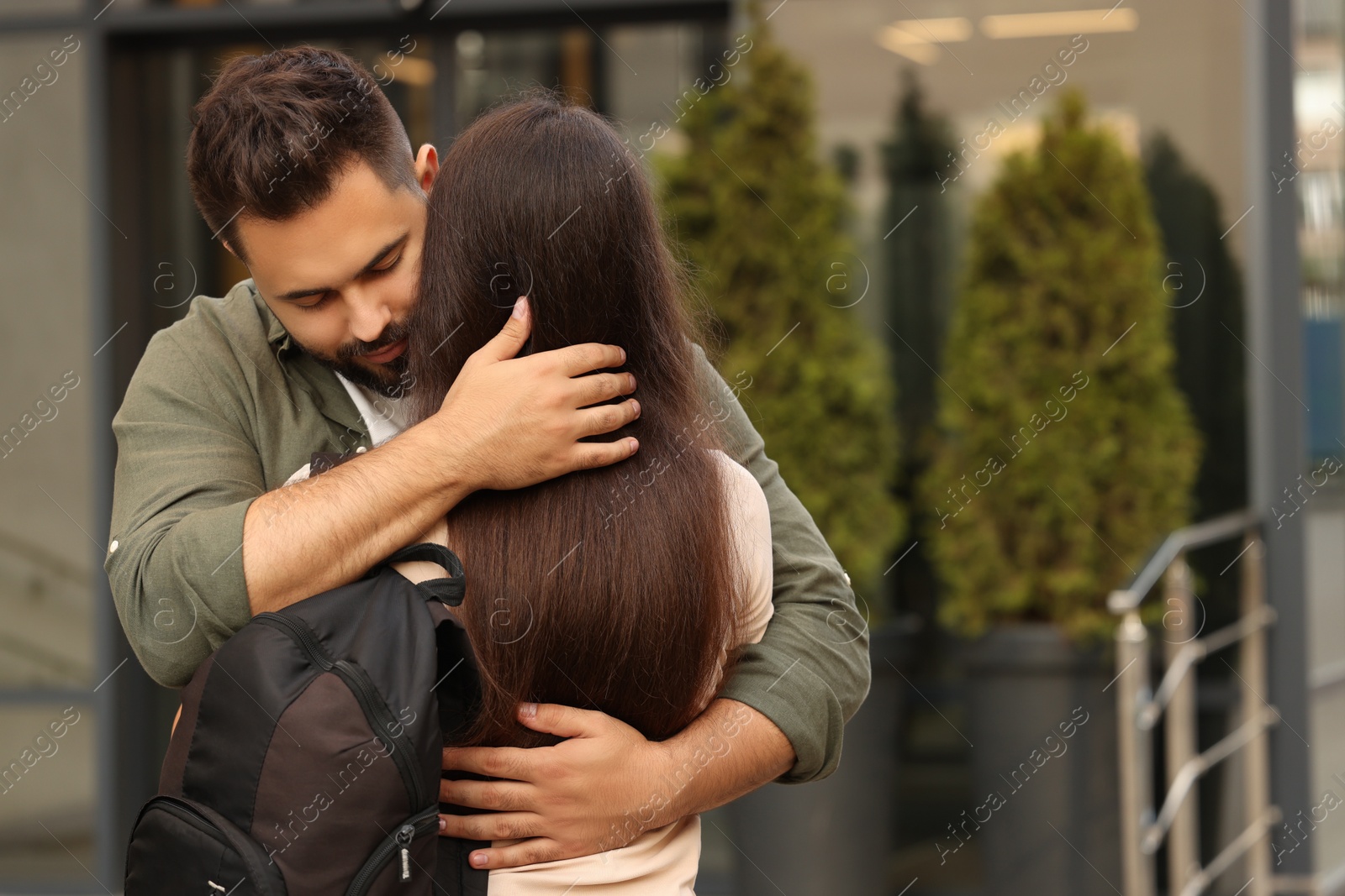 Photo of Long-distance relationship. Young couple with backpack hugging outdoors, space for text