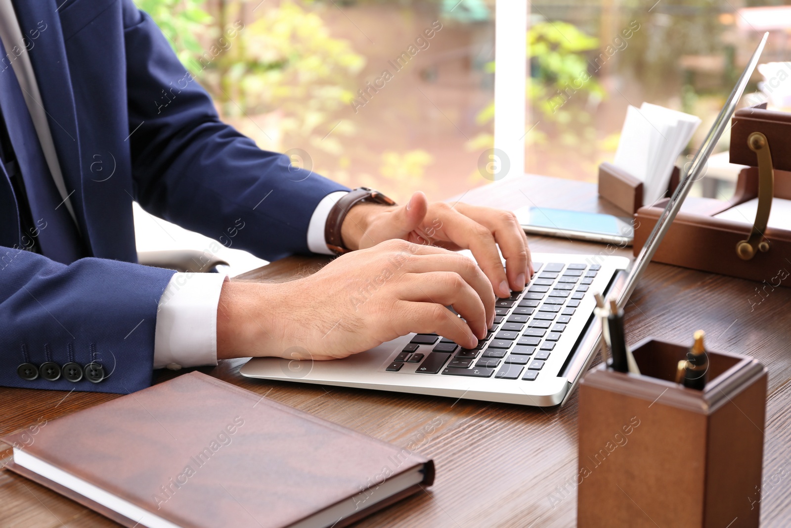 Photo of Lawyer working with laptop at table, focus on hands