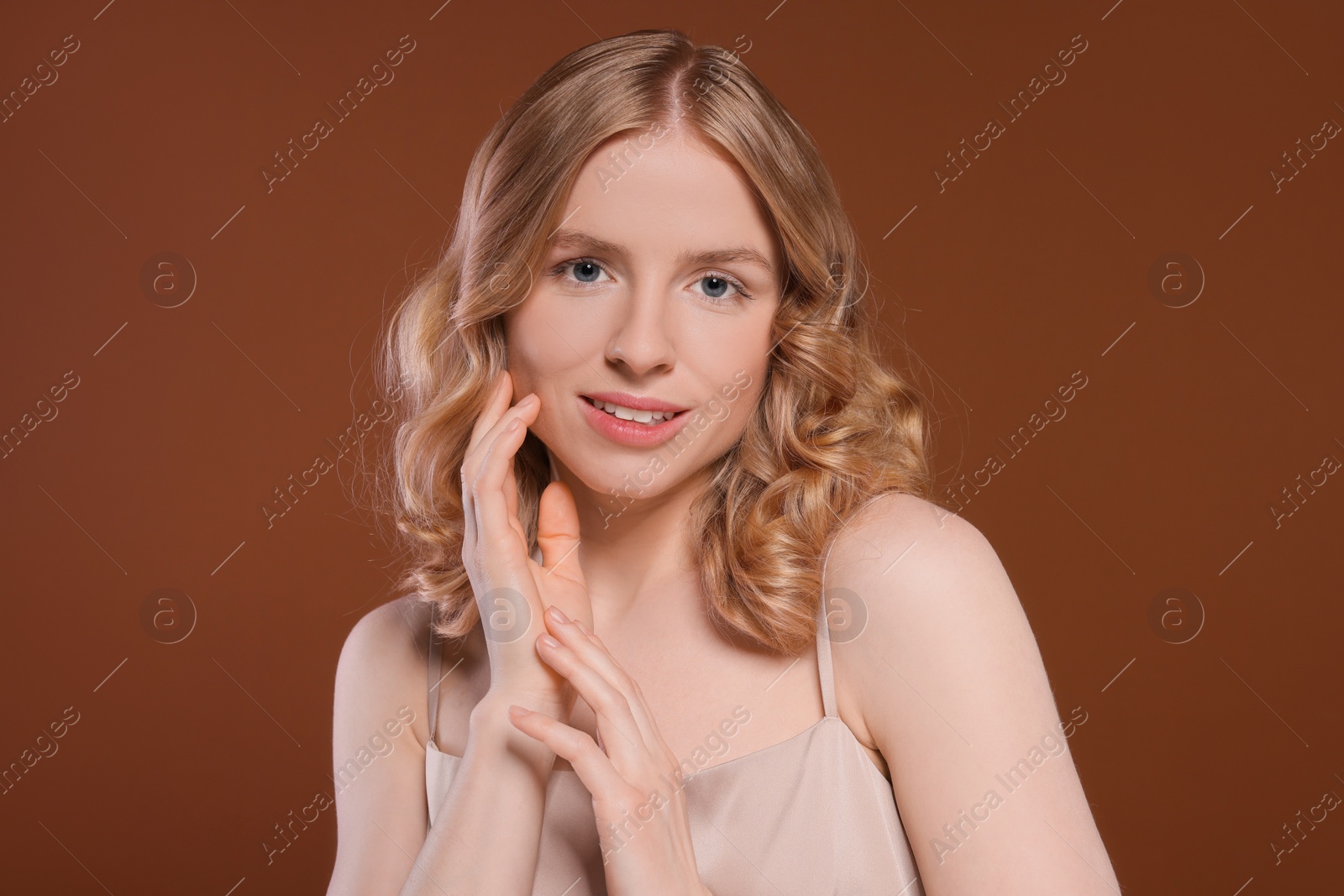 Photo of Portrait of beautiful woman with blonde hair on brown background