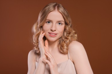 Portrait of beautiful woman with blonde hair on brown background