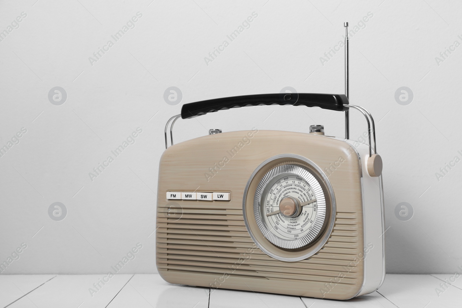 Photo of Retro radio receiver on white wooden table