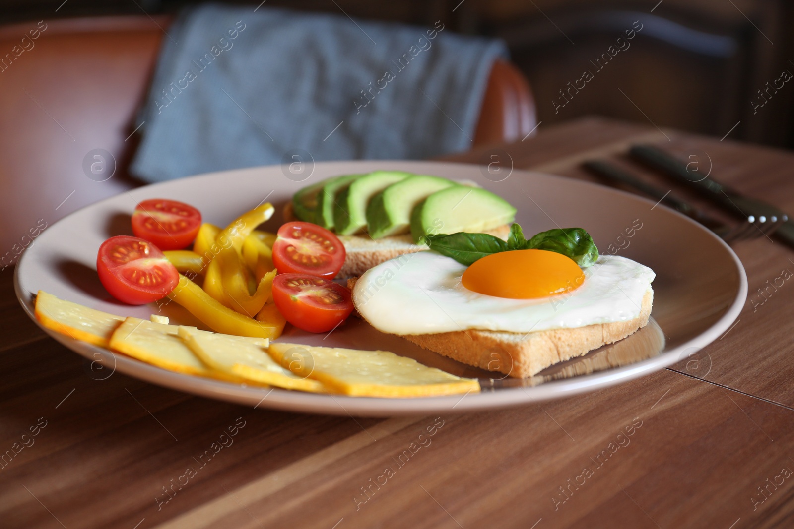 Photo of Tasty toasts with fried egg, avocado, cheese and vegetables on wooden table, closeup