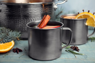 Photo of Tasty mulled wine with spices on blue wooden table