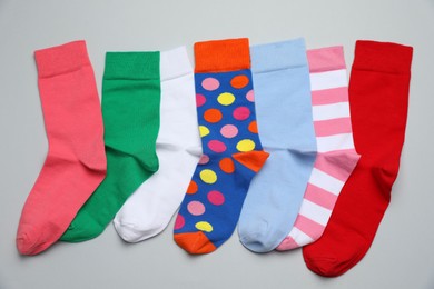 Photo of Many different colorful socks on light grey background, flat lay
