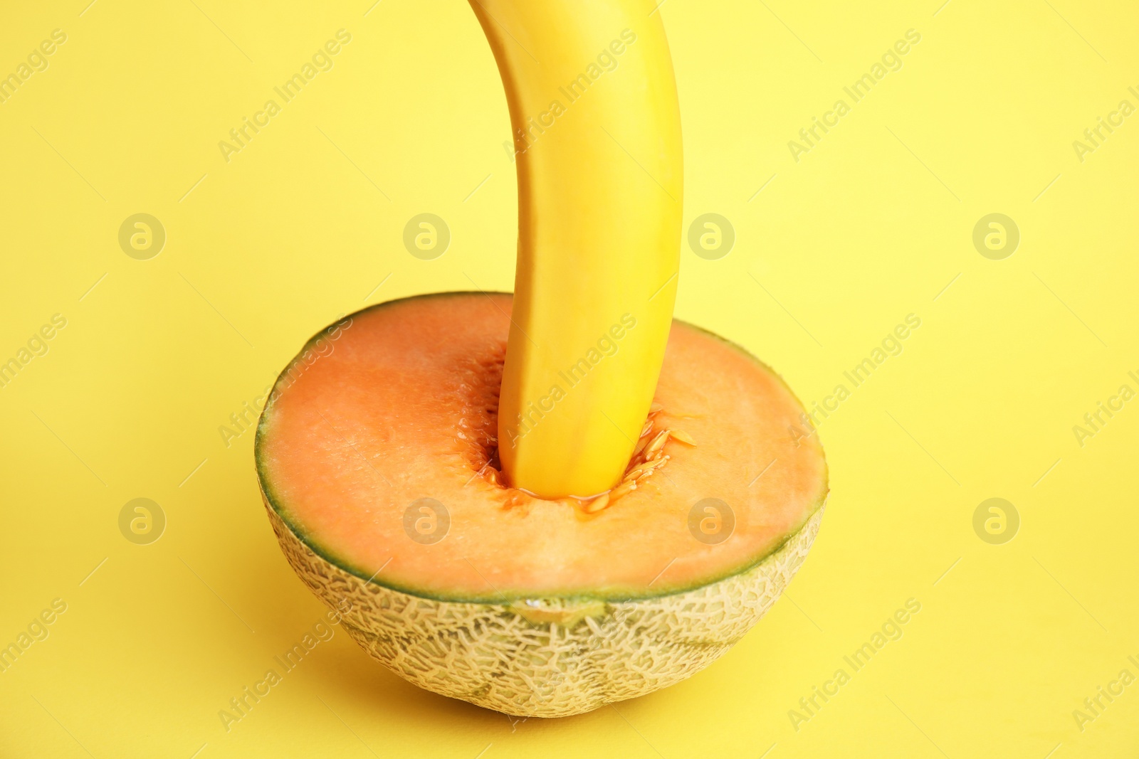 Photo of Fresh banana and melon on yellow background. Sex concept