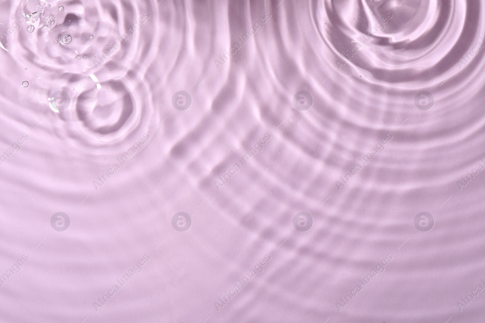 Photo of Closeup view of water with rippled surface on violet background