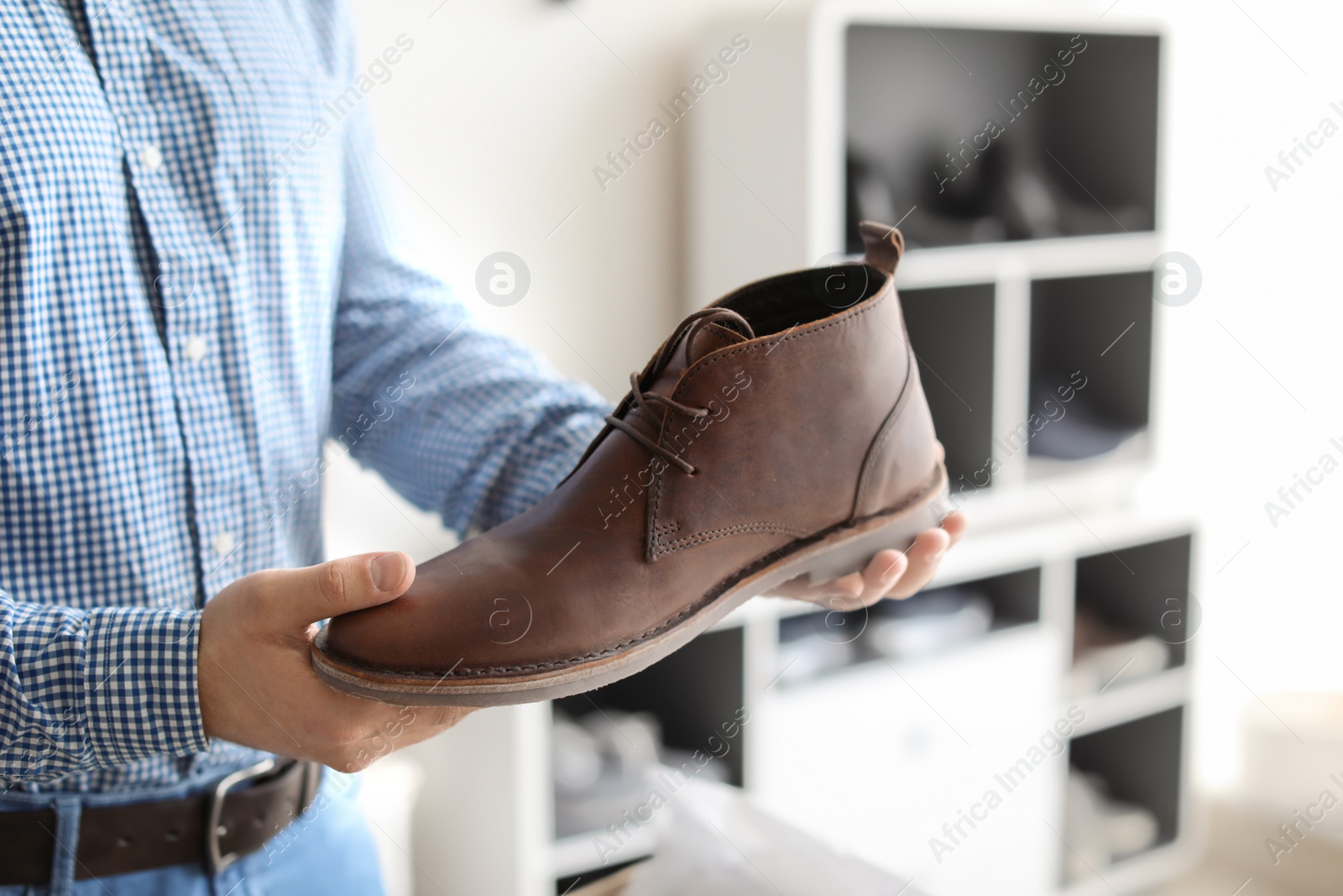 Photo of Young man choosing shoes in store