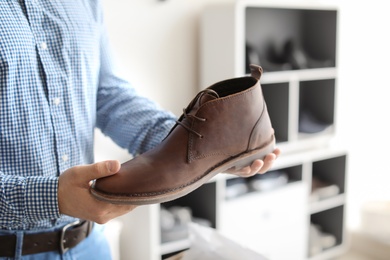 Young man choosing shoes in store