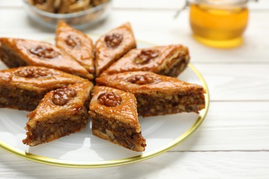 Delicious sweet baklava with walnuts on white wooden table, closeup