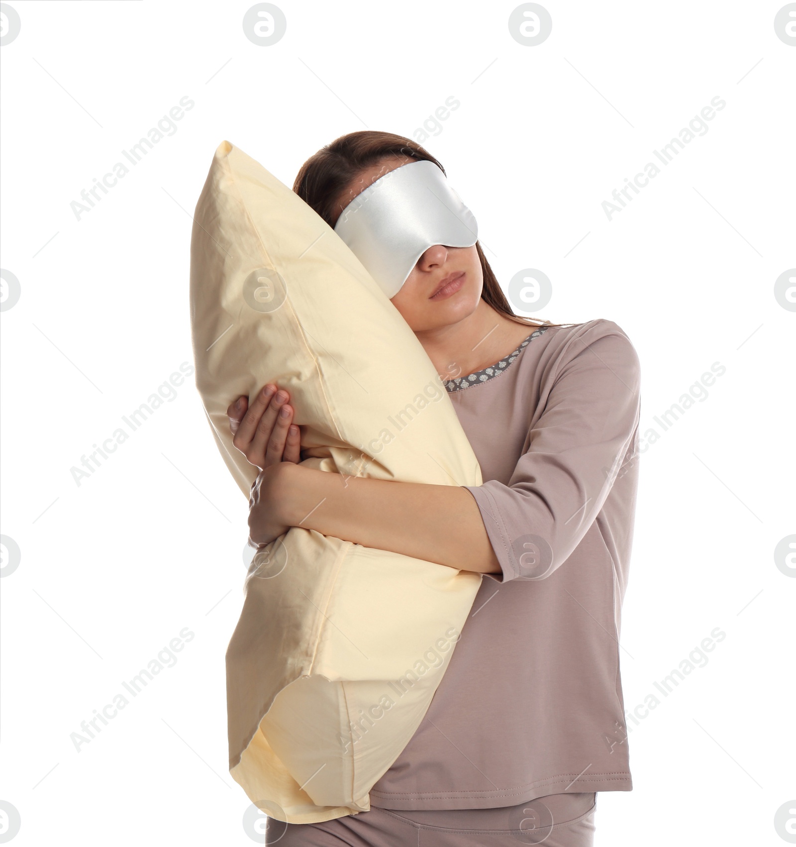 Photo of Young woman wearing pajamas and mask with pillow in sleepwalking state on white background