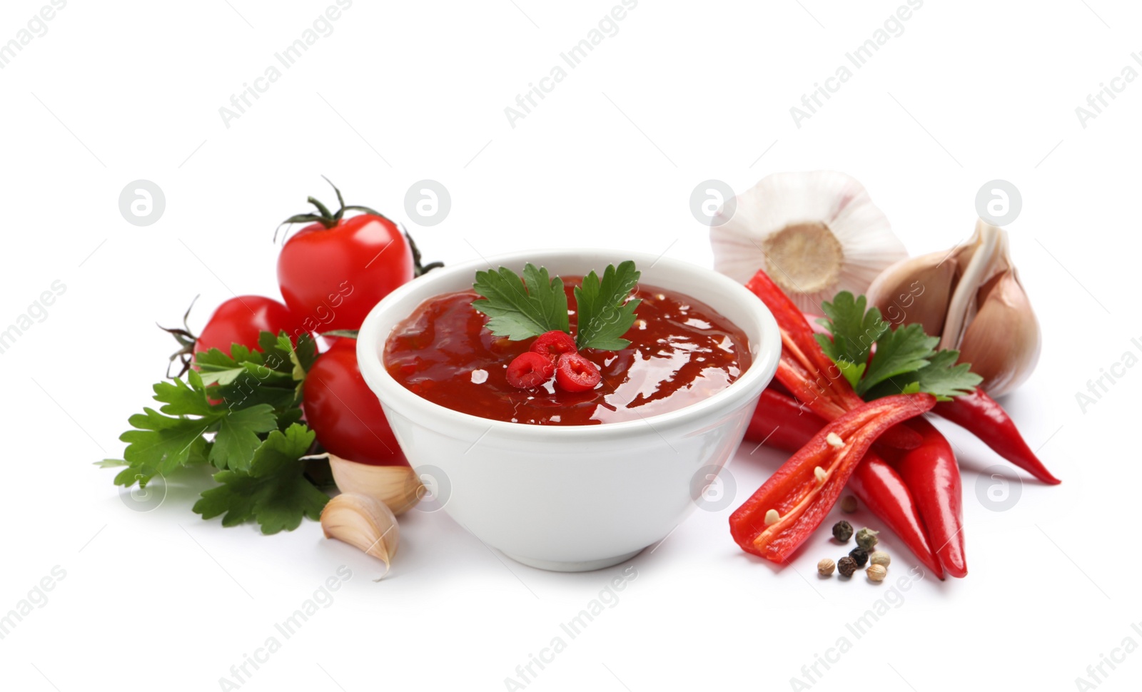 Photo of Spicy chili sauce and ingredients on white background