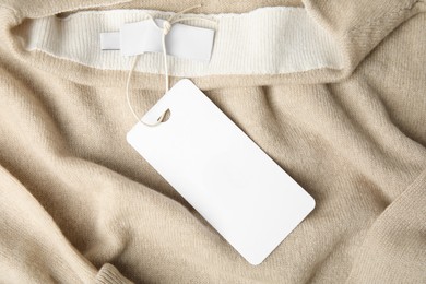 Photo of Warm beige cashmere sweater with tag, closeup