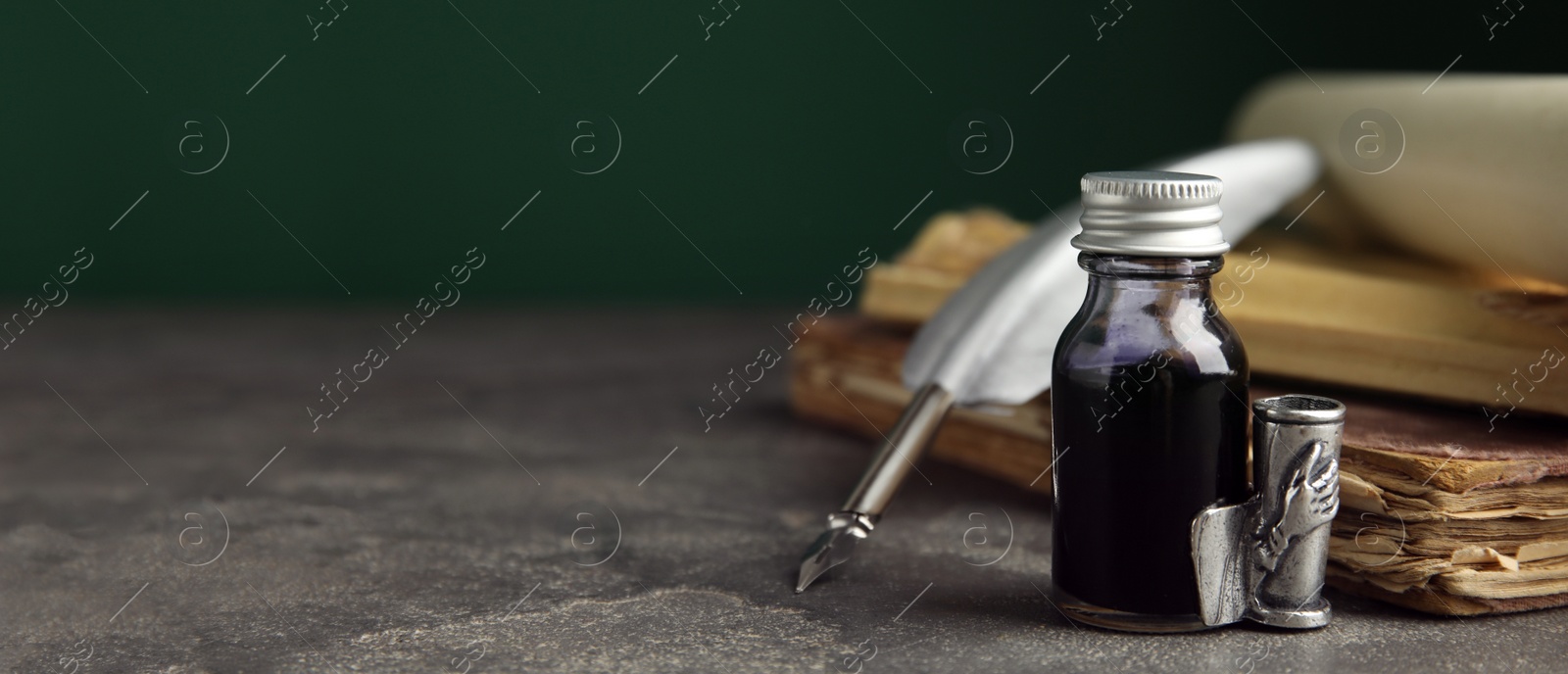 Image of Composition with quill and bottle of ink on grey table, space for text. Banner design